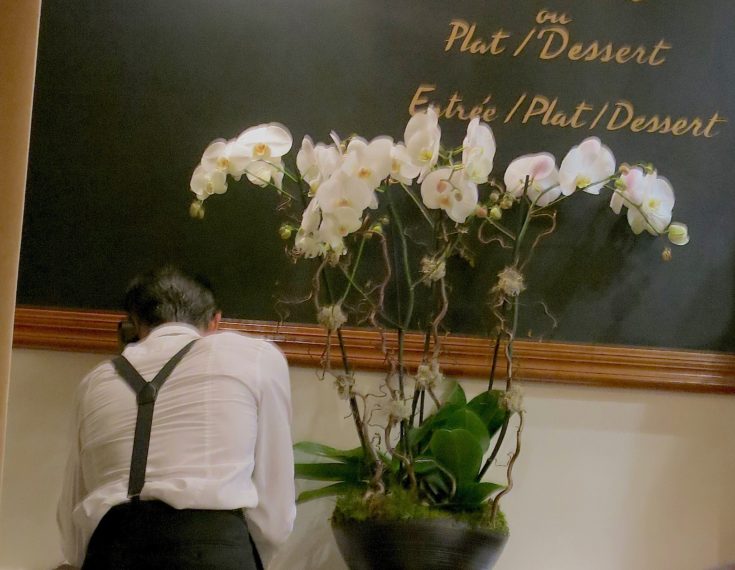 Waiter with orchids @Alexander Lobrano
